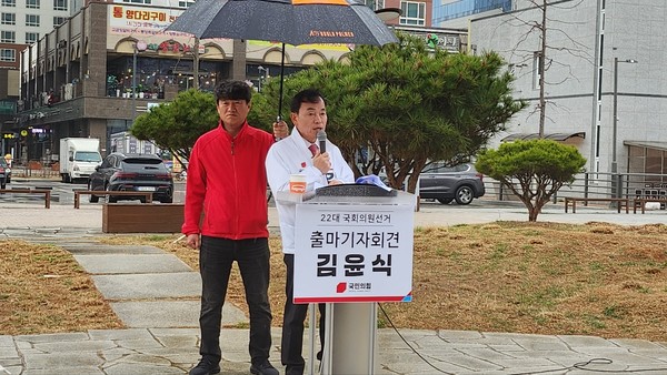 김윤식 후보가 조정식 후보 선거사무소 맞은편 공터에서 우중 출마기자회견을 하고 있는 모습