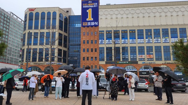 김윤식 후보가 조정식 후보 선거사무소 맞은편 공터에서 우중 출마기자회견을 하고 있는 모습을 취재하는 기자들 모습